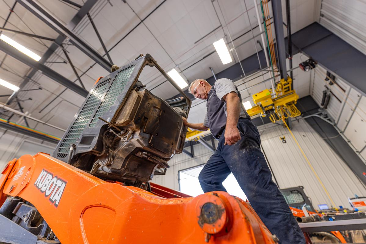 man looking under cab of Kubota skid steer